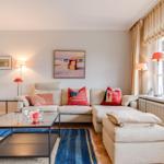 Wohnzimmer mit Sofa, Couchtisch und Fenster mit Jalousie.