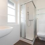 Badezimmer mit Dusche, Waschbecken und Toilette.