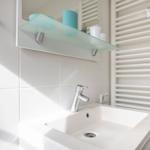 Bad mit Waschbecken, Spiegel und Heizkörper