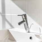 Moderne Waschbecken mit Chromarmatur und weißen Fliesen