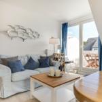 Wohnzimmer mit Sofa, Couchtisch und Blick auf Balkon
