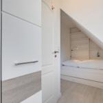 Schlafzimmer mit Dachschräge, Bett und Regal