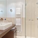 Bad mit Dusche, Waschbecken und Handtuchhalter