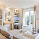 Wohnzimmer mit Sofa, Fernseher und Blick auf Garten