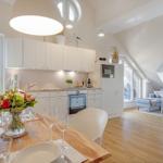 Kitchen with dining area and living room under sloped ceilings.
