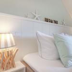 Bedroom with bed, pillows, and nightstand with lamp.
