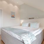 Bedroom with bed, nightstand, and wall decoration.