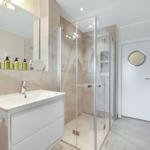 Bathroom with shower, sink, and mirror.