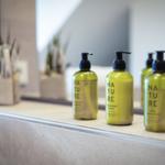 Bathroom with green Nature soap bottles and plant on sink