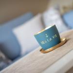 A blue cup with gold lettering sits on a table.