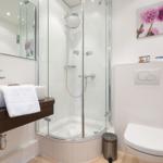 Badezimmer mit Dusche, Waschbecken und Toilette.