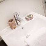 Waschbecken mit Wasserhahn, Seifenspender und Handtuch
