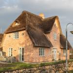 Haus mit Strohdach, Terrasse und Steinmauer