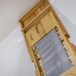 Holzhandtuchhalter mit grauem Handtuch in Bad