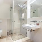 Moderne Badezimmer mit Dusche, Waschbecken und Toilette.