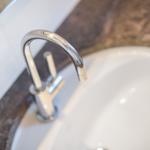 Modern sink with chrome faucet on dark marble countertop.