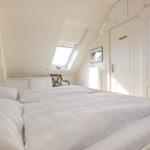 Bedroom with skylight, bed, and wardrobe.