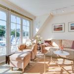 Living room with seating group, glass table, and large window to terrace.