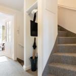 Staircase with carpeted steps, closet, and entrance to living area.