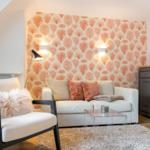 Living room with sofa, armchair, and decorative wallpaper