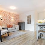 Living and dining area with sofa, table, and kitchenette.