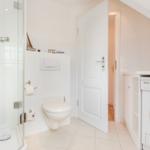 Bathroom with shower, toilet, and washing machine.