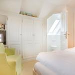 Bedroom with bed, wardrobe, and TV. Door leads to the toilet.