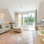 Living and dining area with terrace, sofa, dining table, and TV.