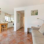 Living and dining area with terracotta floor, sofa, and dining table.