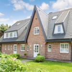 Red brick house with dormers and white entrance