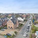 City view with houses, streets, and sea in the background.