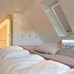 Attic room with bed, wardrobe, and skylight.