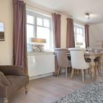 Dining room with table, chairs, and windows with curtains.