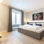 Schlafzimmer mit Bett, Fenster und Wandbild.