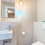 Badezimmer mit Waschbecken, Spiegel und Toilette