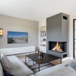 Wohnzimmer mit Kamin, Sofa und Fernseher an der Wand.