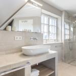 Bathroom with shower, sink, and window