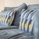 A sofa with two pillows in striped pattern.