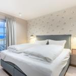 Bedroom with sea view and seagull wallpaper.