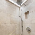 Shower cabin with shower head, handheld shower, and built-in shelf