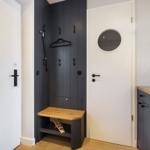 Entrance area with coat rack, bench, and mirrors on the wall.