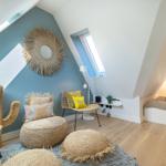 Attic room with daybed, seating area, and sloped ceiling.