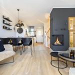 Living and dining area with fireplace, dining table, and sofa on wooden floor.