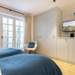 Bedroom with double bed, TV, and large window.