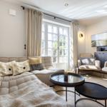 Living room with sofa, armchairs, and TV mounted on the wall