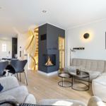 Living and dining area with fireplace, sofa, and table.