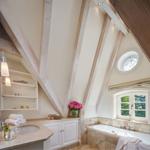 Bathroom with bathtub, sink, and wooden beams on the ceiling.