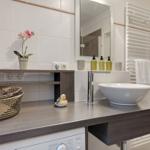 Sink with mirror, towel warmer, and decorative items.