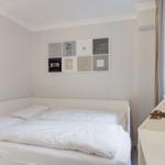Bedroom with white bed and wall art.