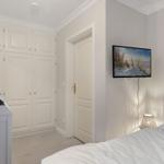Bedroom with bed, wardrobe, and wall-mounted TV